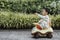 An adorable toddler Asian boy 1-year-old siting and enjoy to play Ride-on toys outdoor in the garden with grass background