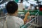 An Adorable toddler Asian boy 1-year-old sitting and play inside the trolley with blurry supermarket background