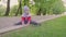 Adorable toddler boy, child playing on a road with blooming trees on sunset