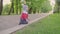 Adorable toddler boy, child playing on a road with blooming trees on sunset