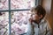 Adorable toddler boy looking out of the window