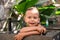 Adorable toddler boy playing and bathing in stone sink outdoors