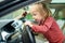 Adorable toddler boy playing in the driver`s seat. Cute little son sitting in fathers car