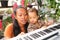 Adorable toddler boy in shirt with mom playing piano