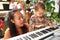 Adorable toddler boy in shirt with mom playing piano