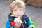 Adorable toddler eating bread outdoor