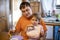 Adorable toddler enjoys eating popsicle ice cream on parent`s lap