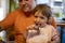 Adorable toddler enjoys eating popsicle ice cream on parent`s lap