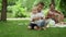 Adorable toddler falling on grass in park. Parents laughing with kids outdoors