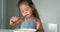 Adorable toddler girl eat pasta spaghetti, happy preschool child eating using fork and by hands fresh cooked healthy