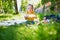 Adorable toddler girl having picnic in countryside on a summer day