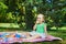 Adorable toddler girl having picnic in countryside on a summer day