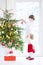 Adorable toddler girl helping her brother to decorate a beautiful Christmas tree