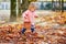 Adorable toddler girl picking chestnuts in Tuileries garden in Paris, France