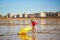 Adorable toddler girl playing on the sand beach near large yellow buoy at Atlantic coast of Brittany, France