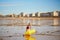 Adorable toddler girl playing on the sand beach near large yellow buoy at Atlantic coast of Brittany, France