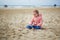 Adorable toddler girl playing on the sand beach in North Holland, the Netherlands