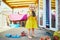 Adorable toddler girl in yellow dress having fun with large pine cone