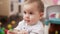 Adorable toddler holding xylophone sticks sitting on floor at kindergarten