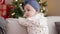 Adorable toddler smiling confident standing on sofa by christmas tree at home