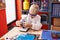 Adorable toddler student using microscope standing at classroom