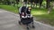 Adorable twin baby girls sleeping in stroller, baby carriage in the park