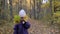 Adorable two years old girl hiding behind maple leaf in autumn forest