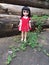 An adorable vintage doll is standing alone in a lonely place