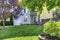 Adorable white house with nice front lawn and trees.