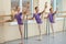 Adorable young ballerinas stretching legs.