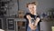 Adorable young girl in apron holding a drill in carpentry. Portrait of a little girl with a drill looking at camera