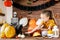 Adorable young girl sitting on a table feeding her cat pumpkin seeds. Halloween lifestyle background.