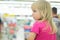 Adorble girl sit in shopping cart in supermarket