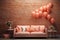 Adorned for romantic holiday, the room showcases airy balloons and comfortable sofas placed adjacent to a peach fuzz-colored brick