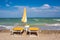 Adriatic Sea coast view. Seashore of Italy, summer umbrellas on sandy beach with clouds on horizon.