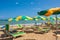 Adriatic Sea coast view. Seashore of Italy, summer umbrellas on sandy beach with clouds on horizon.