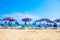 Adriatic Sea coast view. Seashore of Italy, summer umbrellas on sandy beach with clouds on horizon.