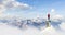 Adult adventurous man standing on top of a snow peak.