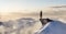 Adult adventurous woman standing on top of a snow peak