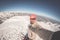 Adult alpin skier with beard, sunglasses and hat, taking selfie on snowy slope in the beautiful italian Alps with clear blue sky.