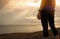 Adult Asian woman wear smart band standing at stone beach. Runner relax after running at tropical beach. Healthy lifestyle. Girl