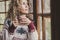 Adult attractive curly blonde woman at home enjoying winter holidays drinking from decorated mug and looking outside wht winwos