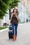 Adult beautiful businesswoman with a suitcase walking along the