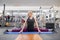 Adult beautiful female blonde doing stretching practicing yoga in gym