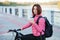 Adult beautiful redhead woman with bob haircut thinking drinking morning coffee posing on bicycle in autumn city river pier