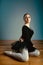 Adult beautiful woman 45-55 years old, ballerina in pointe shoes sits on the floor and poses for the camera. Active old