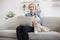 Adult blonde and Westie posing with laptop on laps indoors