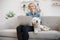 Adult blonde and Westie posing with laptop on laps indoors