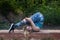 Adult blonde woman doing calisthenics exercises in a ruined house in a forest. Concept of sport and calisthenics