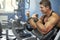 Adult bodybuilder trains biceps in the gym